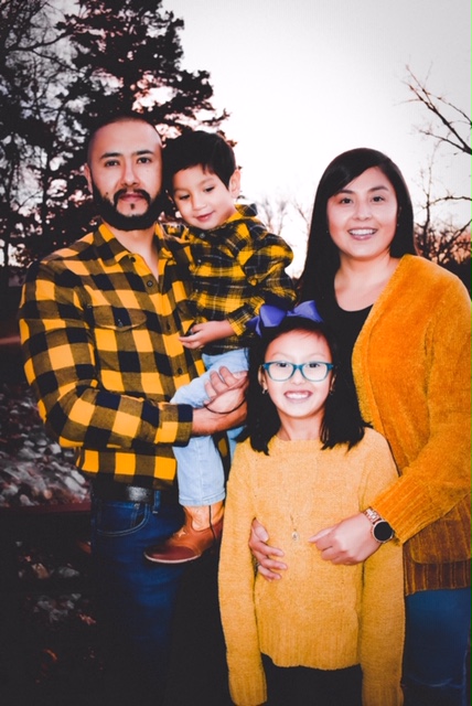 A portrait of Erika Rodriguez with her husband and two children