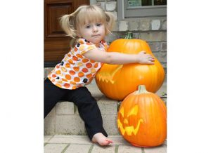 girl hugging pumpkin